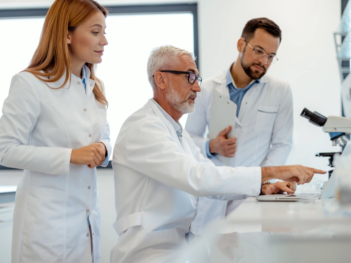 Doctors examining a microscope