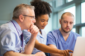 Group of doctors looking at a computer