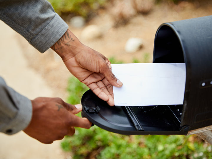 Hand with letter and mailbox
