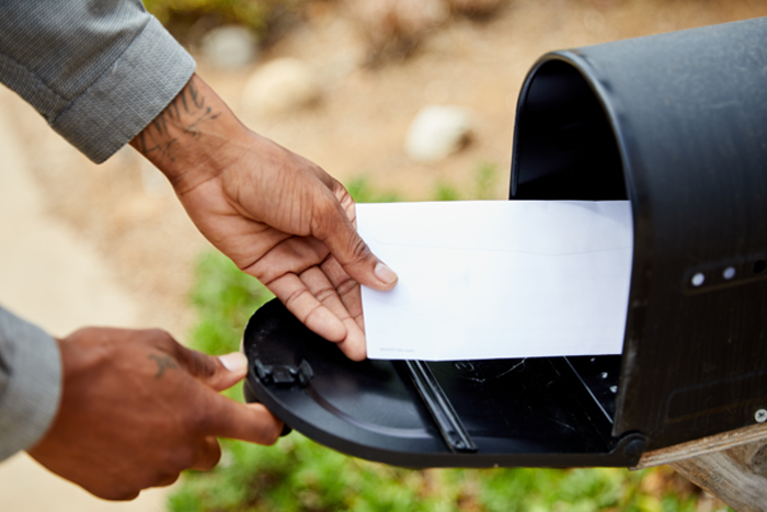 Hand with letter and mailbox